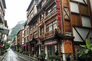 A traditional building with a signboard, a wooden facade, and a balcony. - Zhangjiajie YiShang Inn (Zhangjiajie)