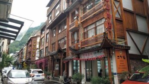 Un edificio tradizionale con diversi piani, balconi in legno e una segnaletica che indica che si tratta di un hotel.