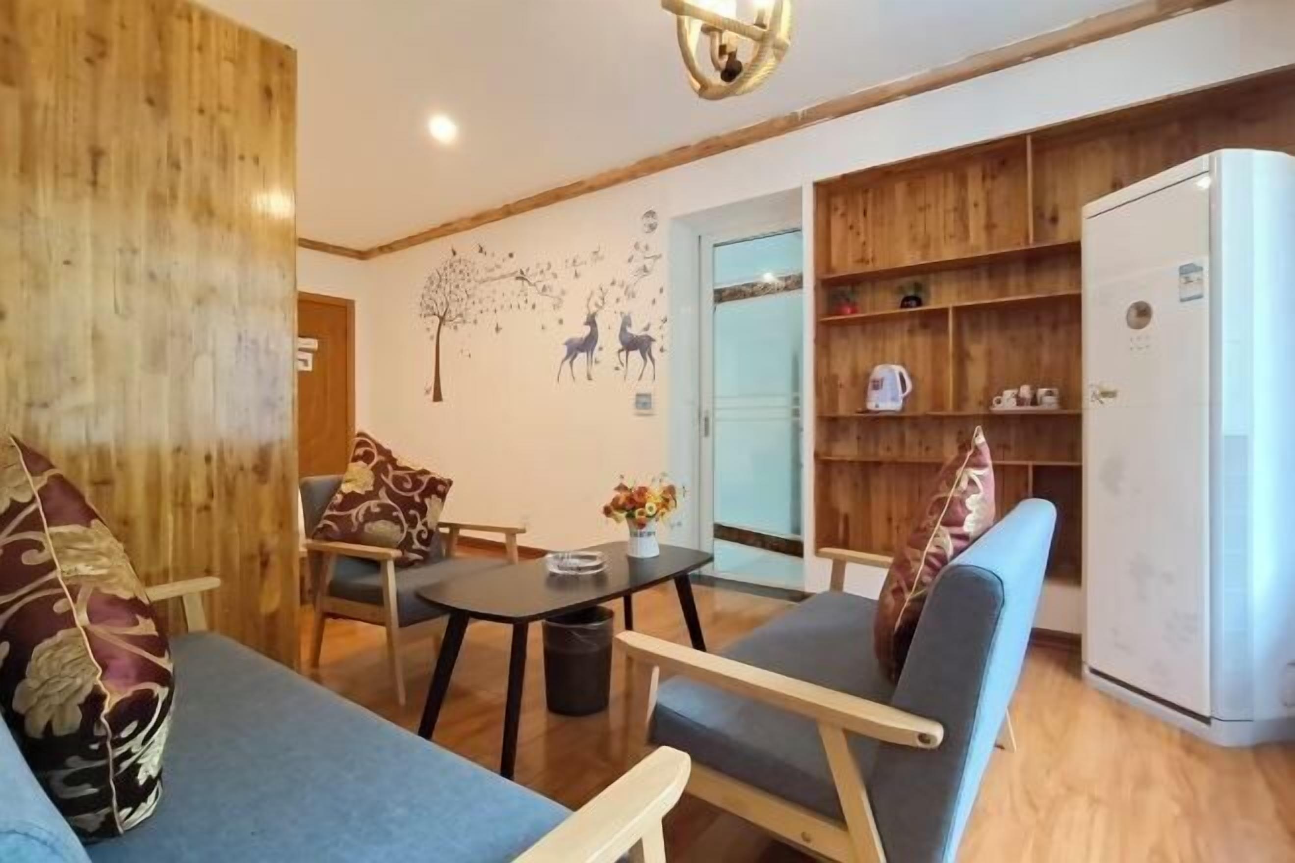 Una sala de estar acogedora con un sof á, sillones, una mesita y una estantería.