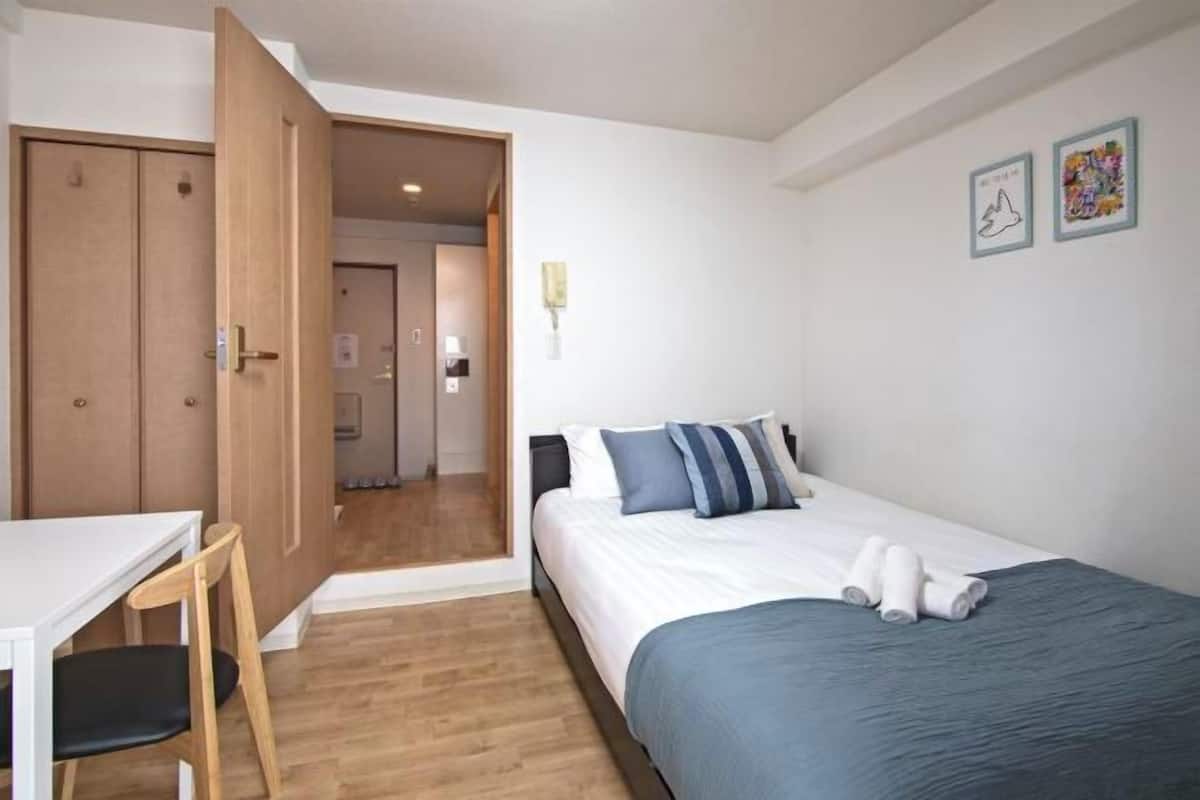 Ein Schlafzimmer mit einem Bett, einem Schreibtisch und einem Kleiderschrank.