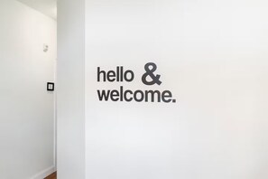 Pared blanca con el texto "hello & welcome".