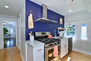 Una cocina moderna con estufa, horno y campana de acero inoxidable.