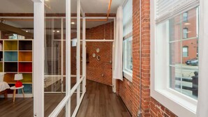 Et interiør med murstensvæg, et vindue og en glasvæg.
