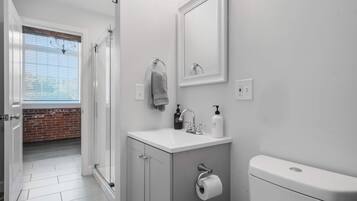 Une salle de bain moderne avec des toilettes, un lavabo et un miroir.