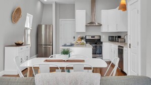 Una cocina moderna con armarios blancos, electrodomésticos de acero inoxidable y una isla central.
