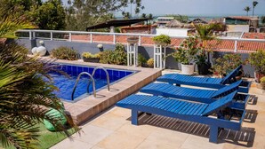A rooftop pool area with a swimming pool, lounge chairs, and potted plants. - Pe na Areia Pousada Jeri (Jijoca de Jericoacoara)