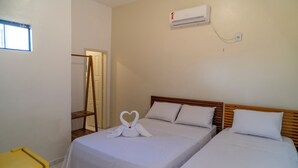 A hotel room with two beds, a wooden headboard, white bedding, and a heart-shaped towel decoration. - Pe na Areia Pousada Jeri (Jijoca de Jericoacoara)