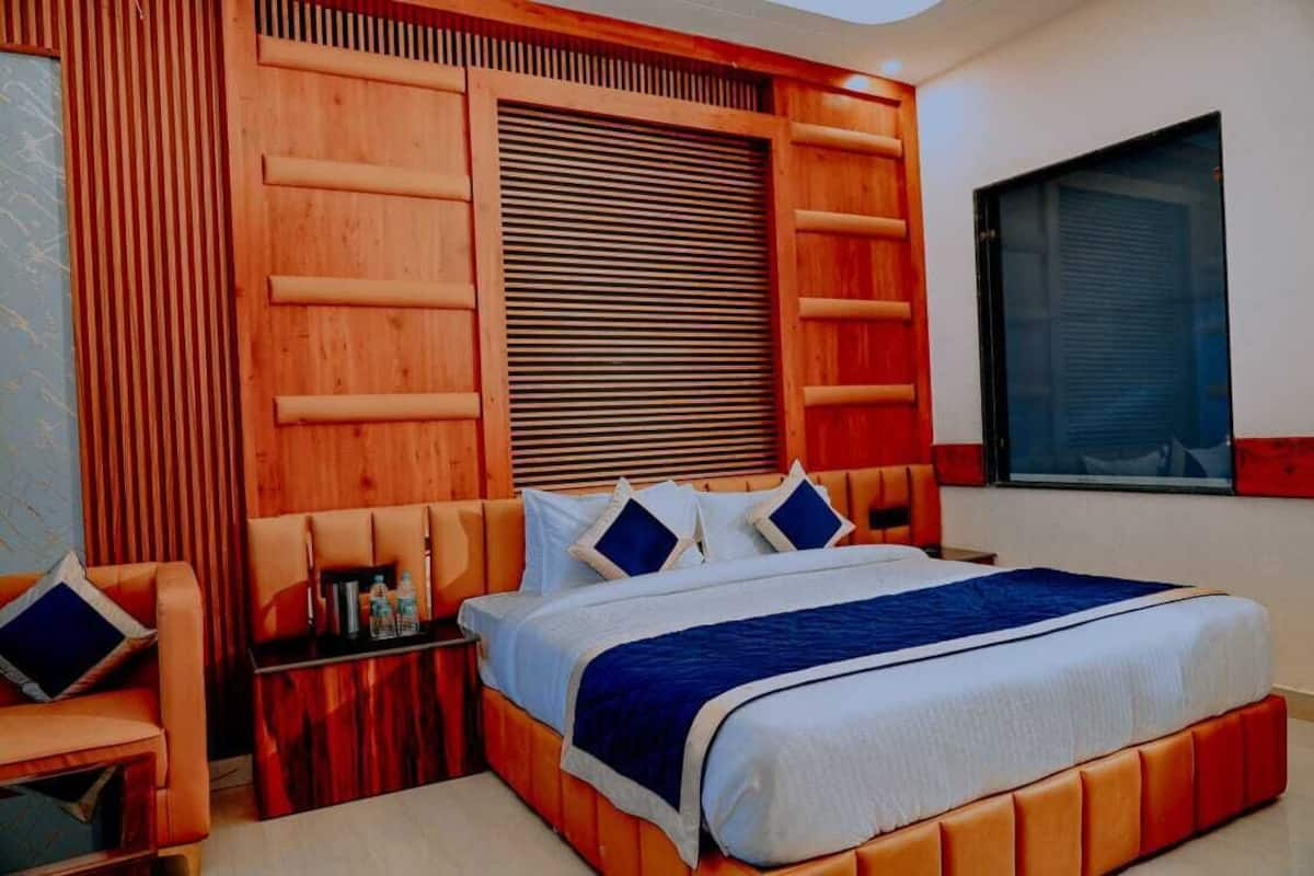 Une chambre à coucher avec un grand lit, une tête de lit en bois et une table de chevet.