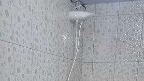A bathroom with a toilet, a handrail, a sink, and a shower. - Pousada Estância da Mata (Nobres)