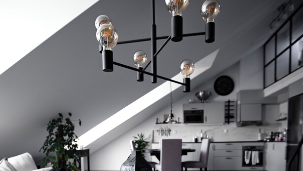 Un appartement moderne de style « loft », doté d’un lit en mezzanine, d’un coin repas et d’une cuisine.