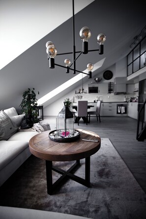 Un moderno loft con letto a soppalco, zona pranzo e cucina.