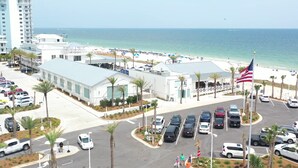Ein Hotel an der Küste mit Parkplatz, Blick auf den Strand und einer amerikanischen Flagge.