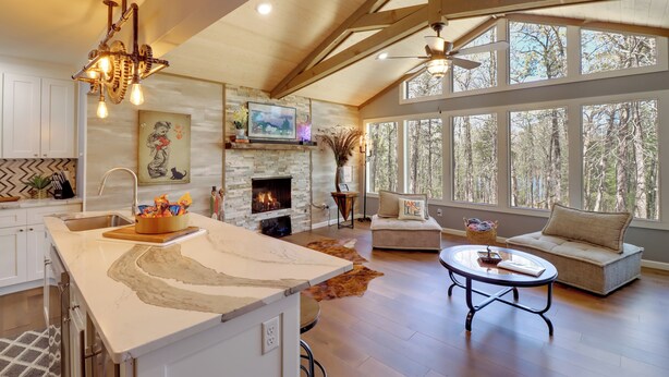 A spacious living area with a fireplace, large windows, and a high ceiling with exposed beams. - Lakeside Retreat on 10 Secluded Wooded Acres, Hot Tub, Level 2 EV Charger (Greers Ferry)