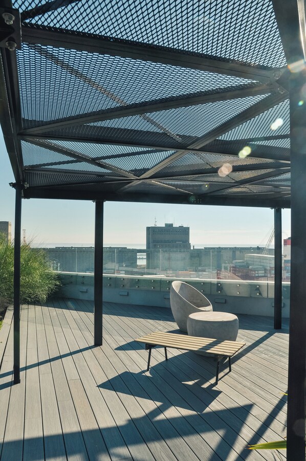 Un espacio de estar techado al aire libre con vista a la ciudad.