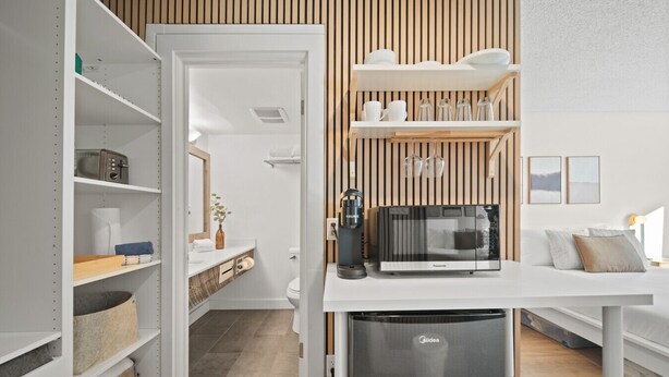 Eine moderne Küche mit integriertem Mikrowellenherd, Kaffeemaschine und Stauraumschränken.