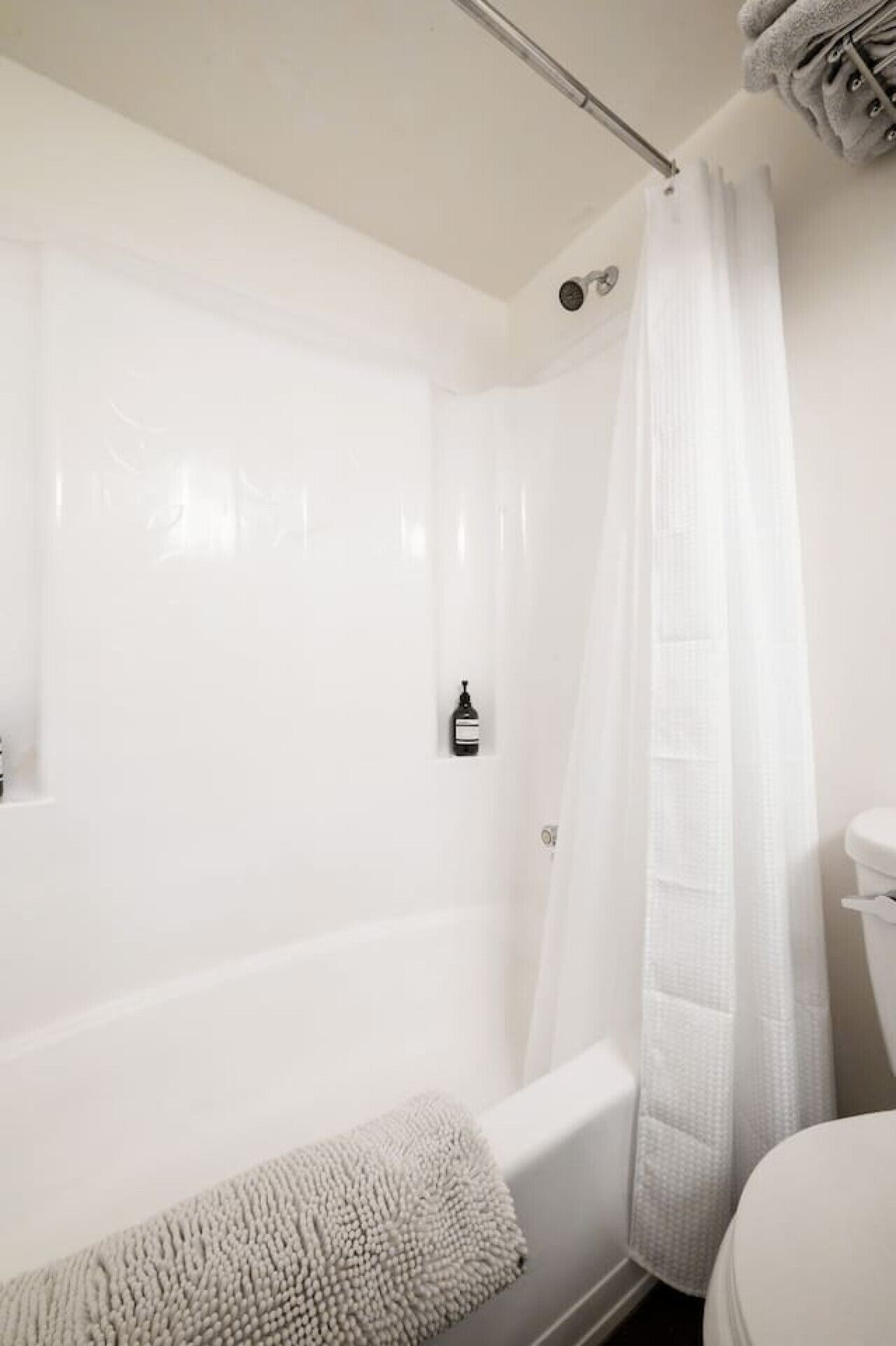 A bathroom with a bathtub, a toilet, and a shower curtain.