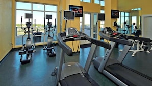 A gym with treadmills, stationary bikes, and elliptical machines.