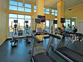 A gym with treadmills, stationary bikes, and elliptical machines.