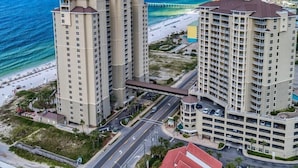 A high-rise hotel with multiple floors, a beach view, and a parking garage.