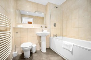 Une salle de bain moderne équipée de toilettes, d’un lavabo et d’une baignoire.