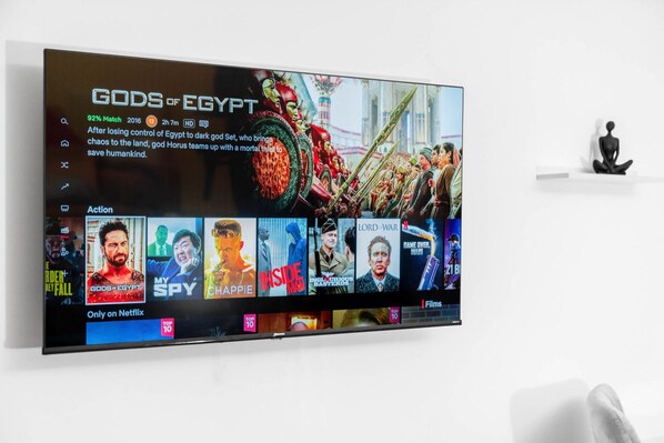 A television displaying the Netflix interface with the movie 'Gods of Egypt' highlighted.