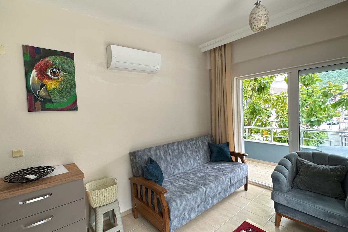A living room with a grey sofa, a wooden cabinet, and a painting on the wall.