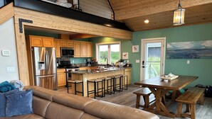Une cuisine moderne avec des meubles en bois, des appareils électroménagers en acier inoxydable et un coin bar.