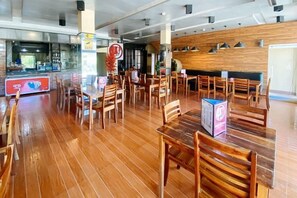 Un restaurant dont le sol, les tables et les chaises sont en bois.