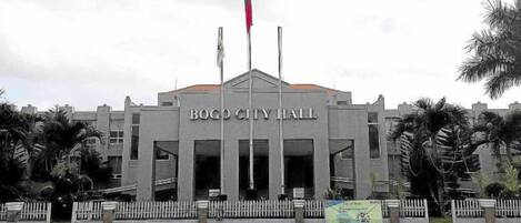 A building with a sign reading 'Bogo City Hall' and multiple flags.
