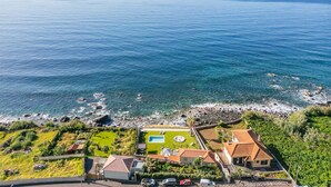 Ein Küstenanwesen mit Swimmingpool, Tennisplatz und Meerblick.