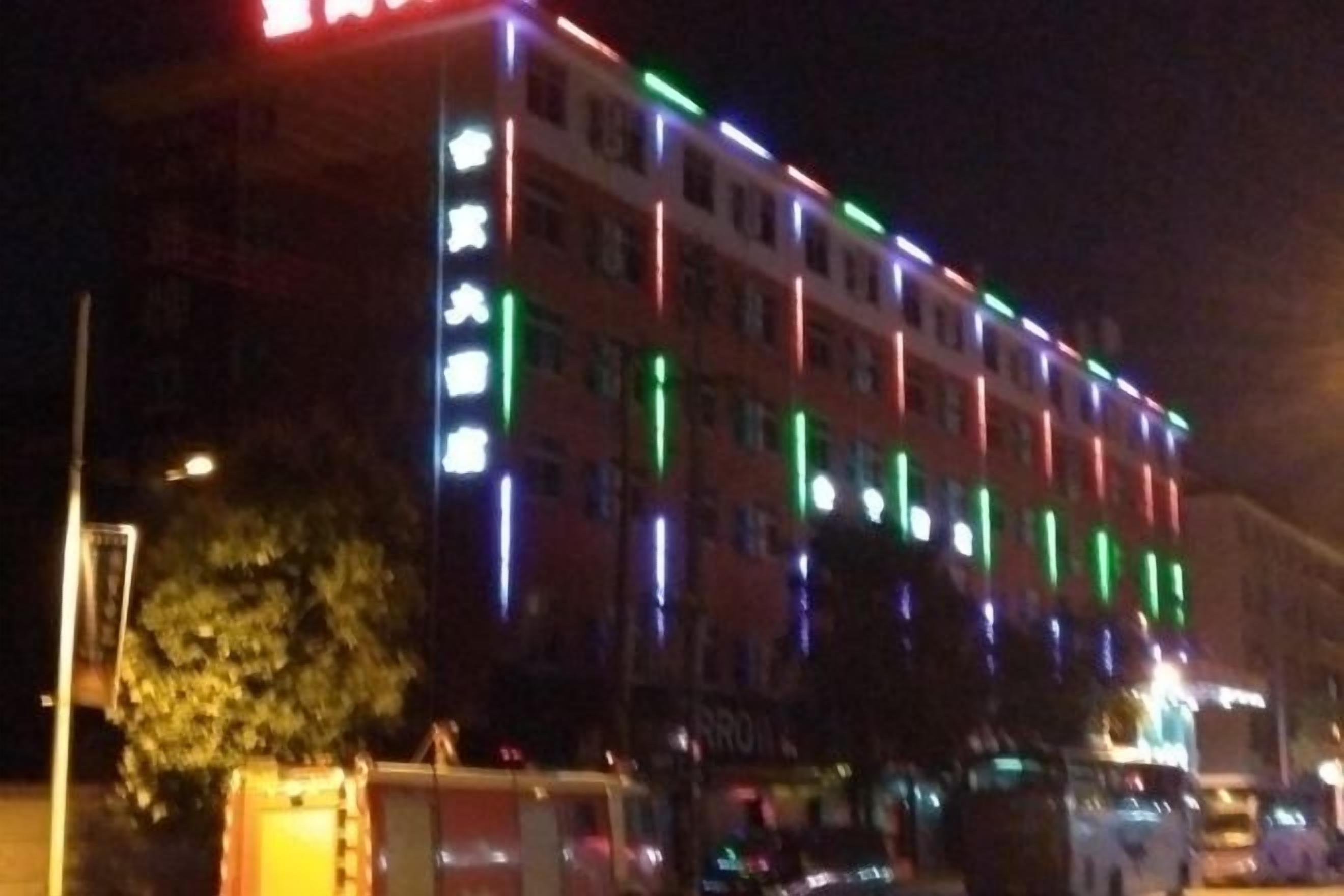 A multi-story building with illuminated signage and a visible entrance.
