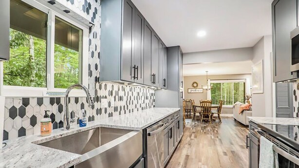 A modern kitchen with a large island, stainless steel appliances, and a patterned backsplash. - Big Red! Modern clubhouse with Hot Tub! Walking distance to Castle - 4 bedrooms (Stanwood)