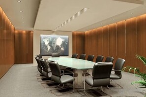A conference room with a glass table surrounded by chairs, a world map on the wall, and wooden paneling. - Manfu Hotel (Beibei Southwest University Zhuangyuanbei Subway Station Branch) (Chongqing)