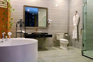A modern bathroom with a large bathtub, a toilet, and a glass shower enclosure. - Manfu Hotel (Beibei Southwest University Zhuangyuanbei Subway Station Branch) (Chongqing)