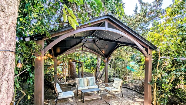 A covered patio area with seating and string lights.