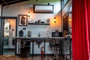 A modern kitchen with a central island, a microwave, and a fire extinguisher.