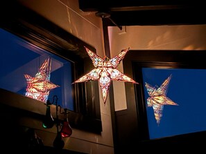 A room with a large, illuminated star-shaped light fixture and a window displaying a colorful, abstract pattern.