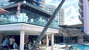 A modern hotel with a pool area, including a waterfall feature and outdoor seating. - Pretty Oceanfront Condo 2 BR w/direct access Beach (Miami)