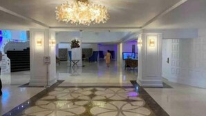 A spacious lobby with a geometric patterned floor, a chandelier, and a staircase in the background. - Pretty Oceanfront Condo 2 BR w/direct access Beach (Miami)