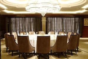 A formal dining room with a round table, chairs, and a chandelier. - Rich Global Hotel (Li County)