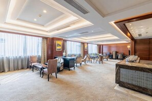 A hotel lobby with a reception desk, seating area, and a large window with curtains. - Rich Global Hotel (Li County)