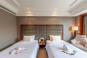 A hotel room with two beds, a wooden headboard, a bedside table with a lamp, and a chair. - Rich Global Hotel (Li County)