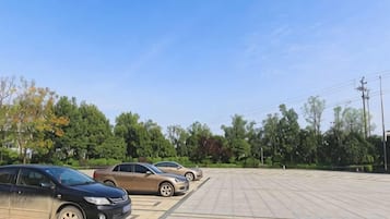 A parking lot with cars and trees in the background.