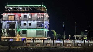 A multi-story building with balconies and a flat roof, illuminated by colorful lights. - Adelina Hotel (Rustenburg)