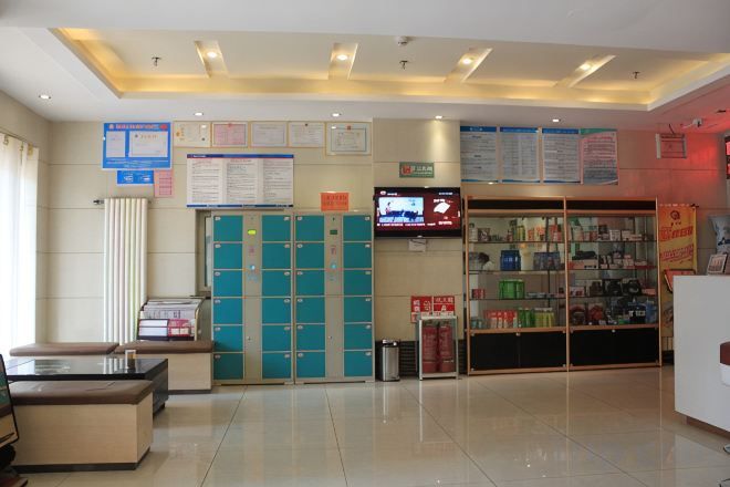Una zona de recepción con mostrador, televisor, tablón de anuncios y farmacia.