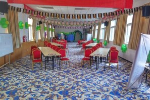 Un salón de banquetes con mesas y sillas dispuestas para eventos.