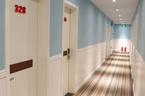 A hotel hallway with doors numbered 328 and 329, a striped carpet, and a fire extinguisher. - Fanke Hotel (Jinan Railway Station South Square Branch ) (Jinan)