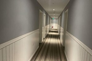 A hallway with white wainscoting, a striped floor, and doors on both sides. - Fanke Hotel (Jinan Railway Station South Square Branch ) (Jinan)
