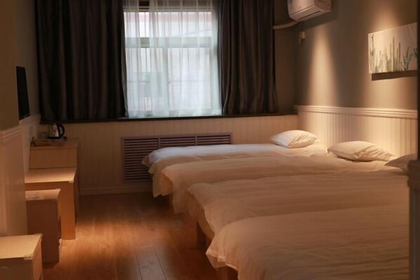 A hotel room with two beds, a window with curtains, a radiator, and a wall-mounted air conditioner. - Fanke Hotel (Jinan Railway Station South Square Branch ) (Jinan)