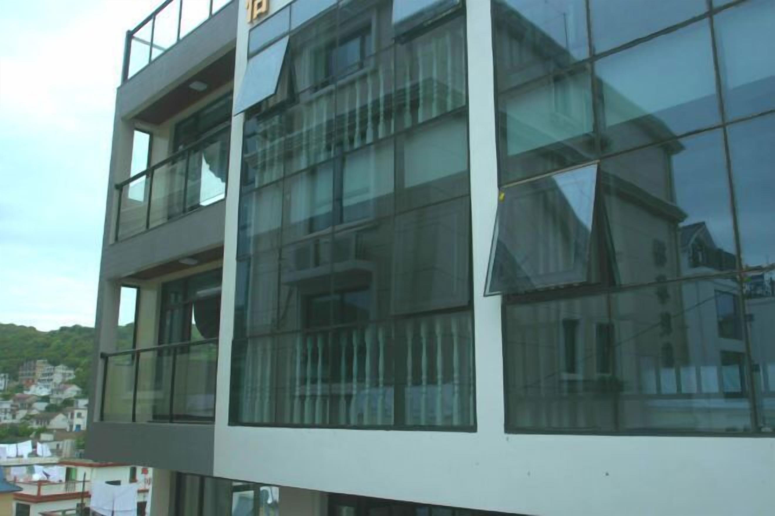 A modern multi-story building with large glass windows and balconies.